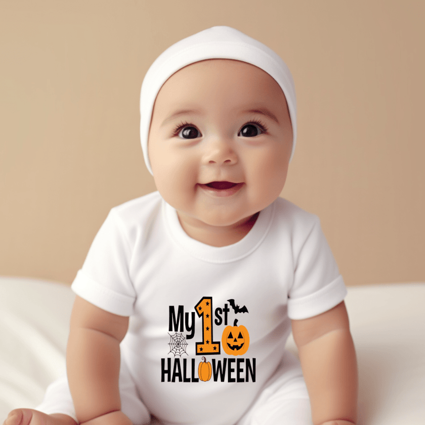 Cute baby wearing a white first Halloween onesie with festive black and orange pumpkin design.