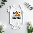 White short sleeve My First Halloween baby onesie hanging on a hanger with pumpkin and bat artwork.