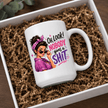 White Nobody Gives a Shit funny mug displayed in gift packaging with brown shredded paper and colourful retro woman artwork.