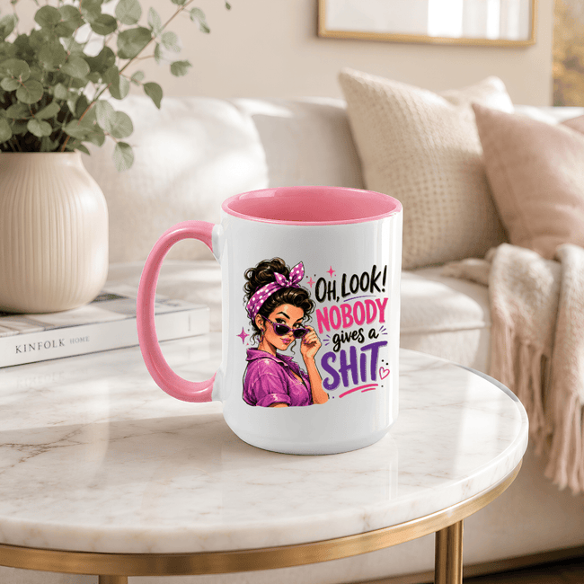 Pink accent funny mug displayed on a modern coffee table with sarcastic Nobody Gives a Shit graphic for women.
