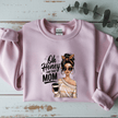 Pink sweatshirt with a graphic of a woman holding a coffee cup and text 'Oh Honey I am that Mom' on a light blue background.