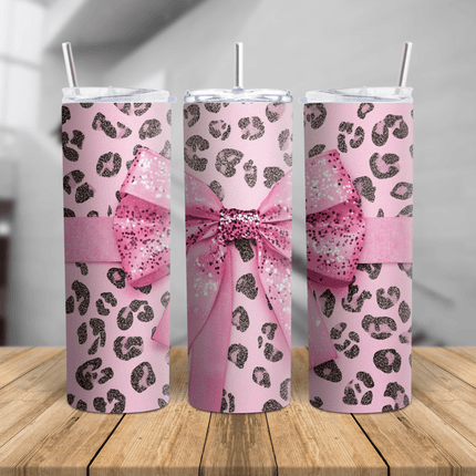 A pink stainless steel tumbler featuring a glitter bow and leopard print design, shown in a 360° view on a wooden surface.
