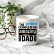 White ceramic coffee mug featuring Prime Example of an Amazing Dad design displayed in hand as a unique Father's Day gift
