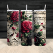 A stainless steel tumbler featuring detailed red and black roses over a vintage music sheet design with floral accents.