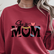 Red crewneck sweater with inspirational She Is Mom text graphic centered on front