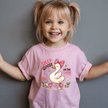 Pink toddler graphic tee showing an adorable goose wearing a bow and sneakers with Silly Goose On The Loose wording.