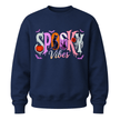 A navy blue crewneck sweatshirt featuring a colorful 'Spooky Vibes' graphic on the chest with Halloween-themed illustrations.