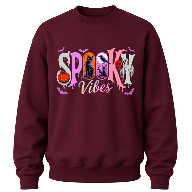 A maroon crewneck sweatshirt featuring a colorful 'Spooky Vibes' graphic on the chest with Halloween-themed illustrations.