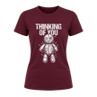 Maroon women’s dark humor graphic tee featuring Thinking of You wording above a pinned voodoo doll illustration