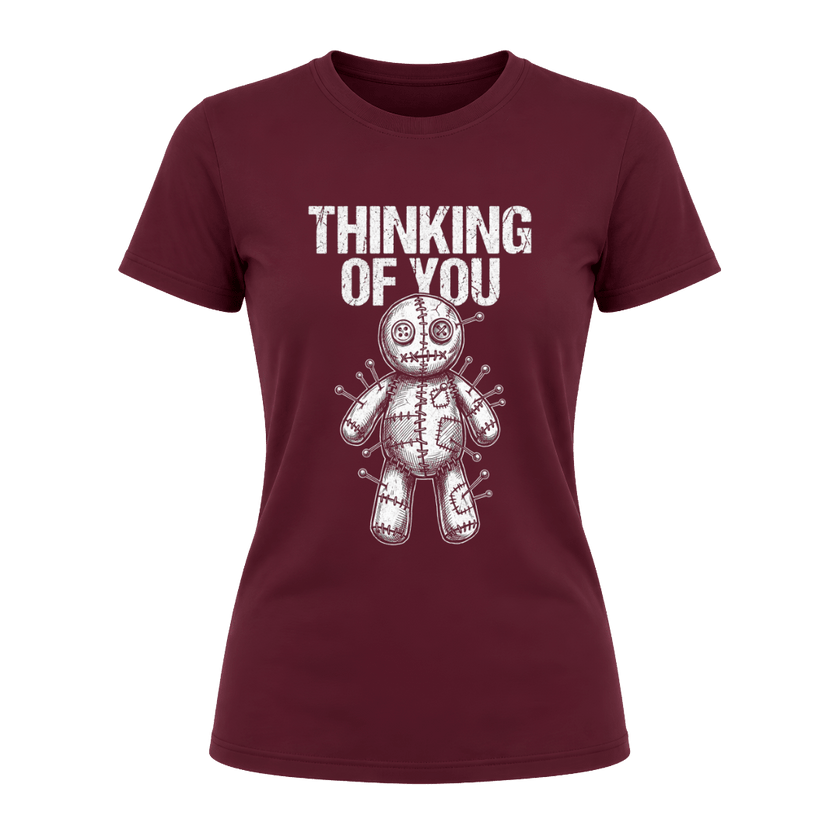 Maroon women’s dark humor graphic tee featuring Thinking of You wording above a pinned voodoo doll illustration