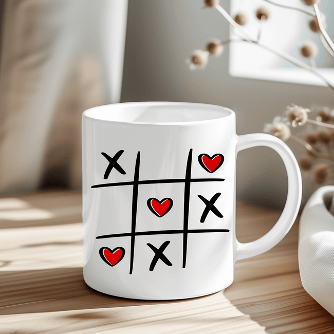 Tic Tac Toe Hearts mug with black grid, X marks, and red heart O's on white ceramic