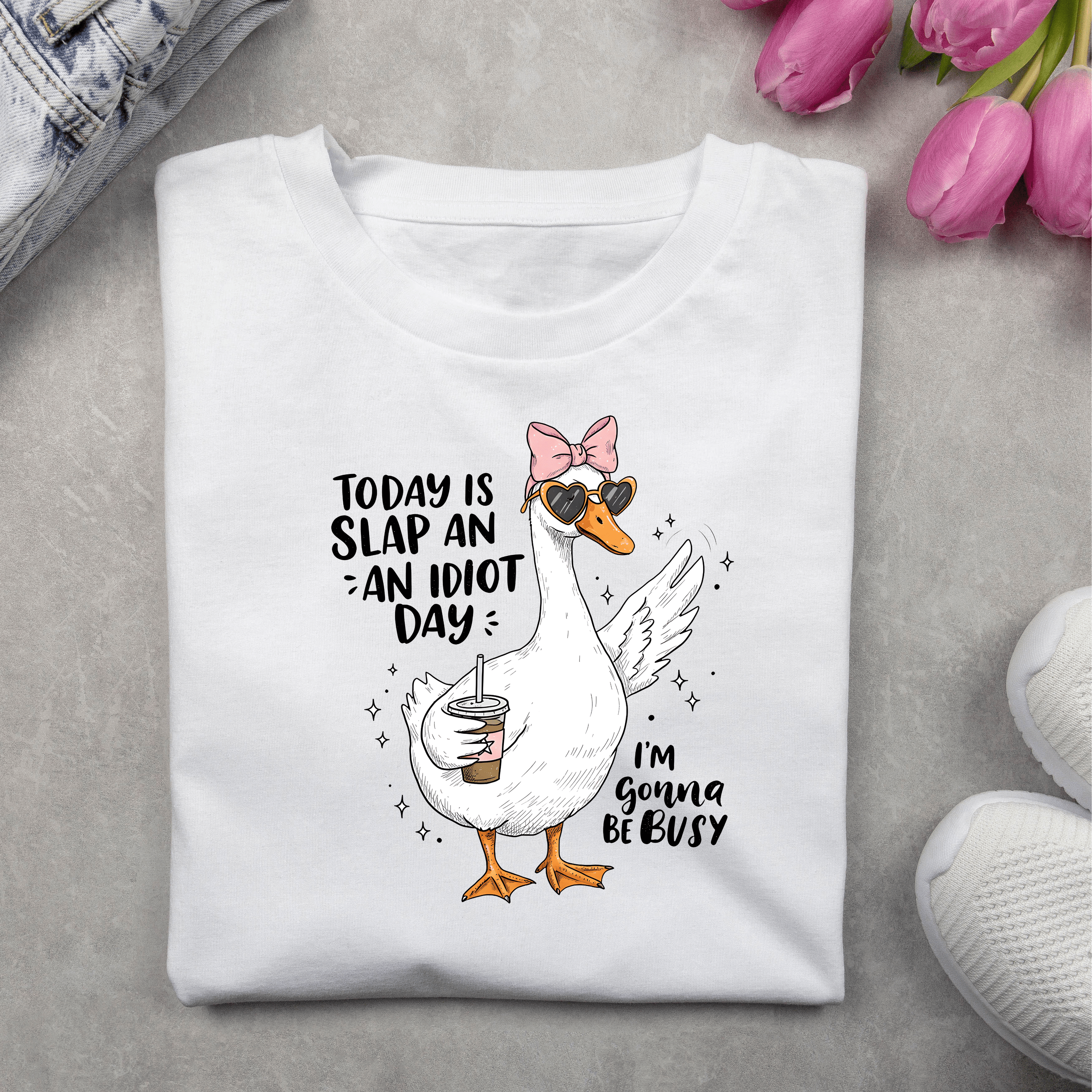 Funny women’s T-shirt with a cute illustrated duck holding a drink, wearing heart-shaped sunglasses and a bow