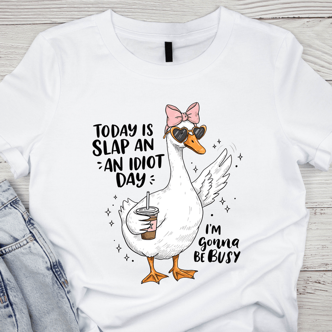 White unisex T-shirt with a cartoon duck wearing sunglasses and a pink bow holding an iced coffee