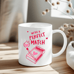 We're a Perfect Match mug with red matchstick heart design on white ceramic