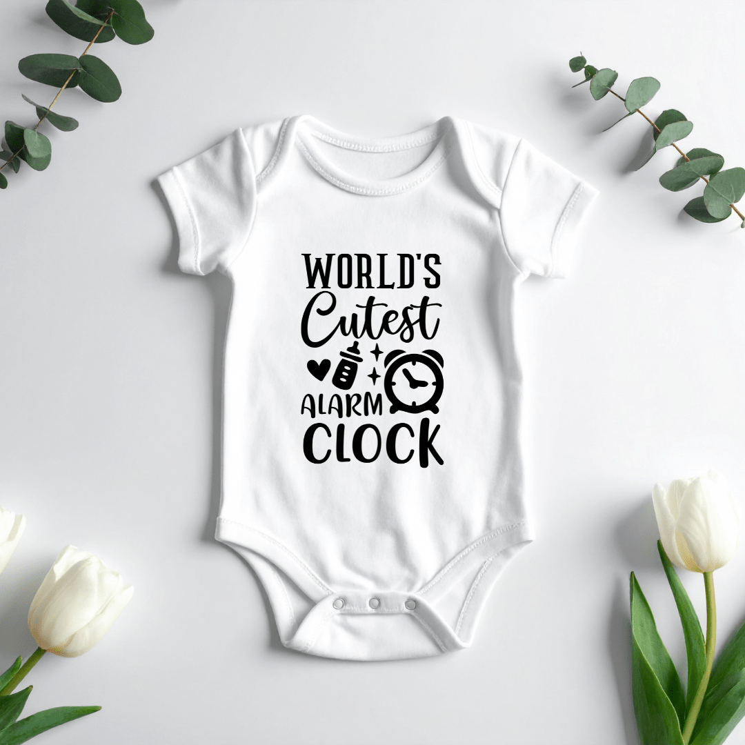 White baby onesie featuring World’s Cutest Alarm Clock graphic with bottle and clock illustration for newborn babies