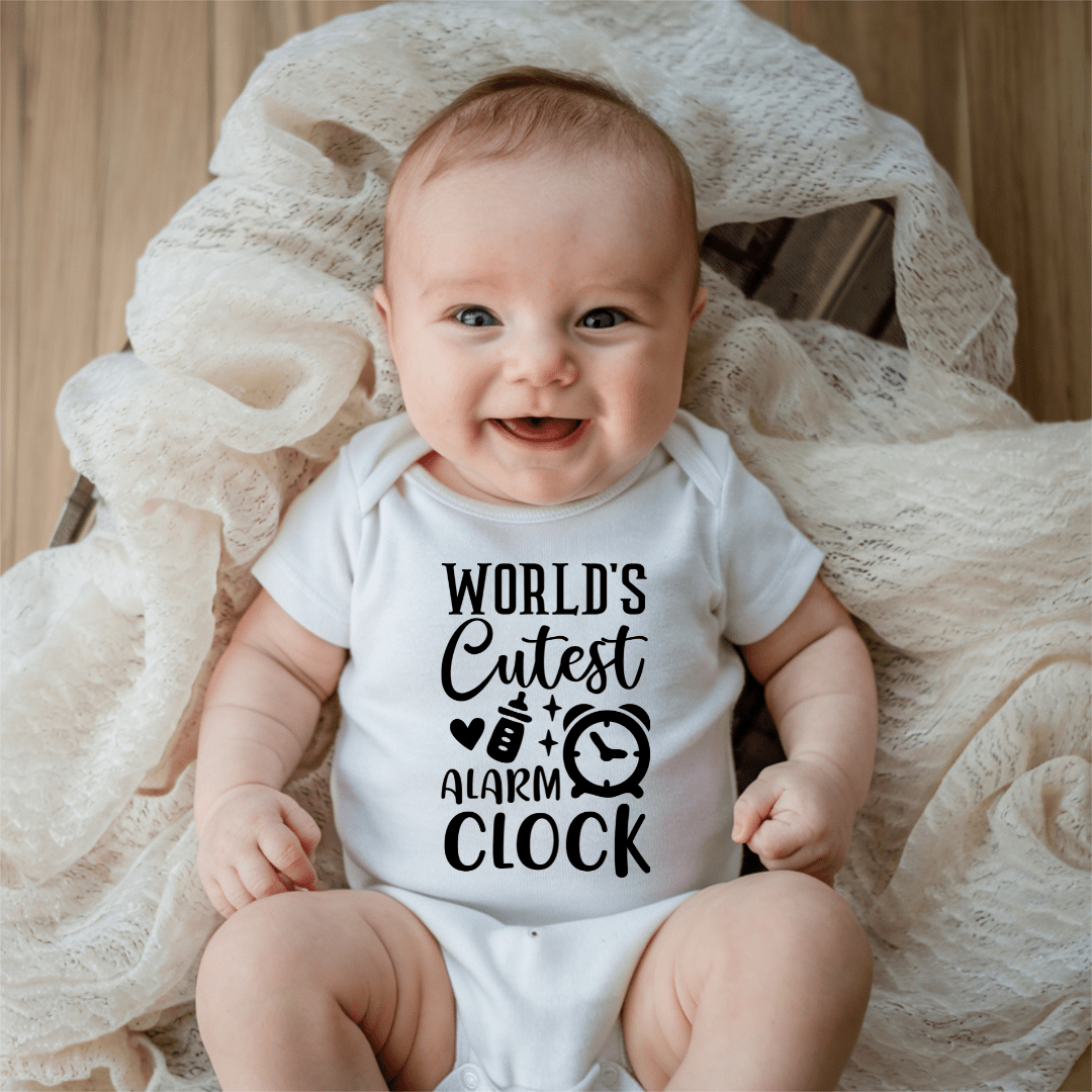 Smiling baby wearing funny World’s Cutest Alarm Clock infant bodysuit in soft white cotton fabric