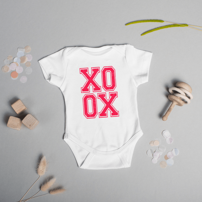 Front view of infant onesie showing centered pink XO XO text