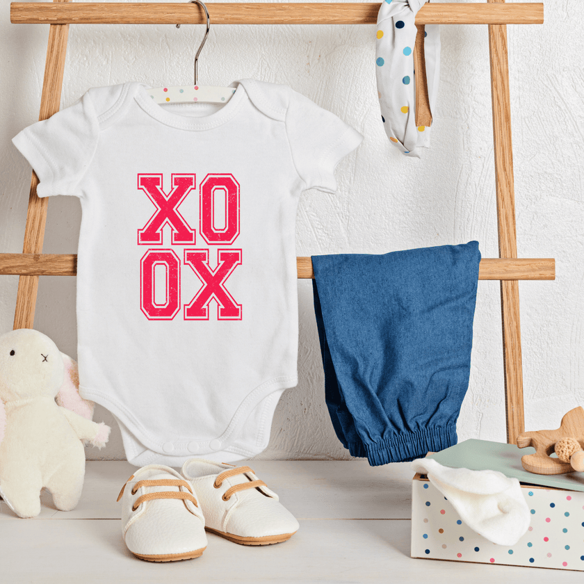 Styled XO XO bodysuit on nursery ladder with blue pants, and toys