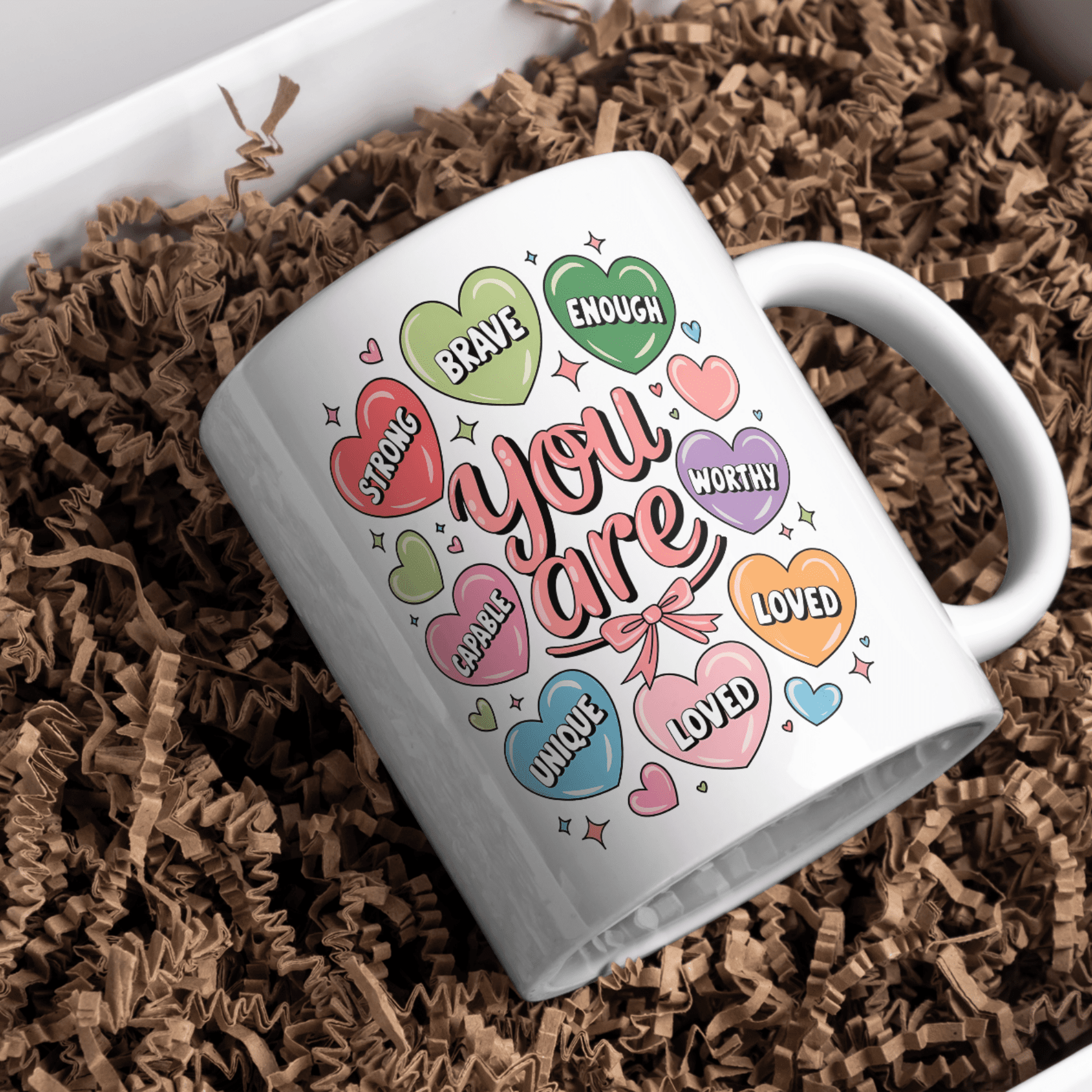 White ceramic mug featuring pastel candy hearts with affirmations 