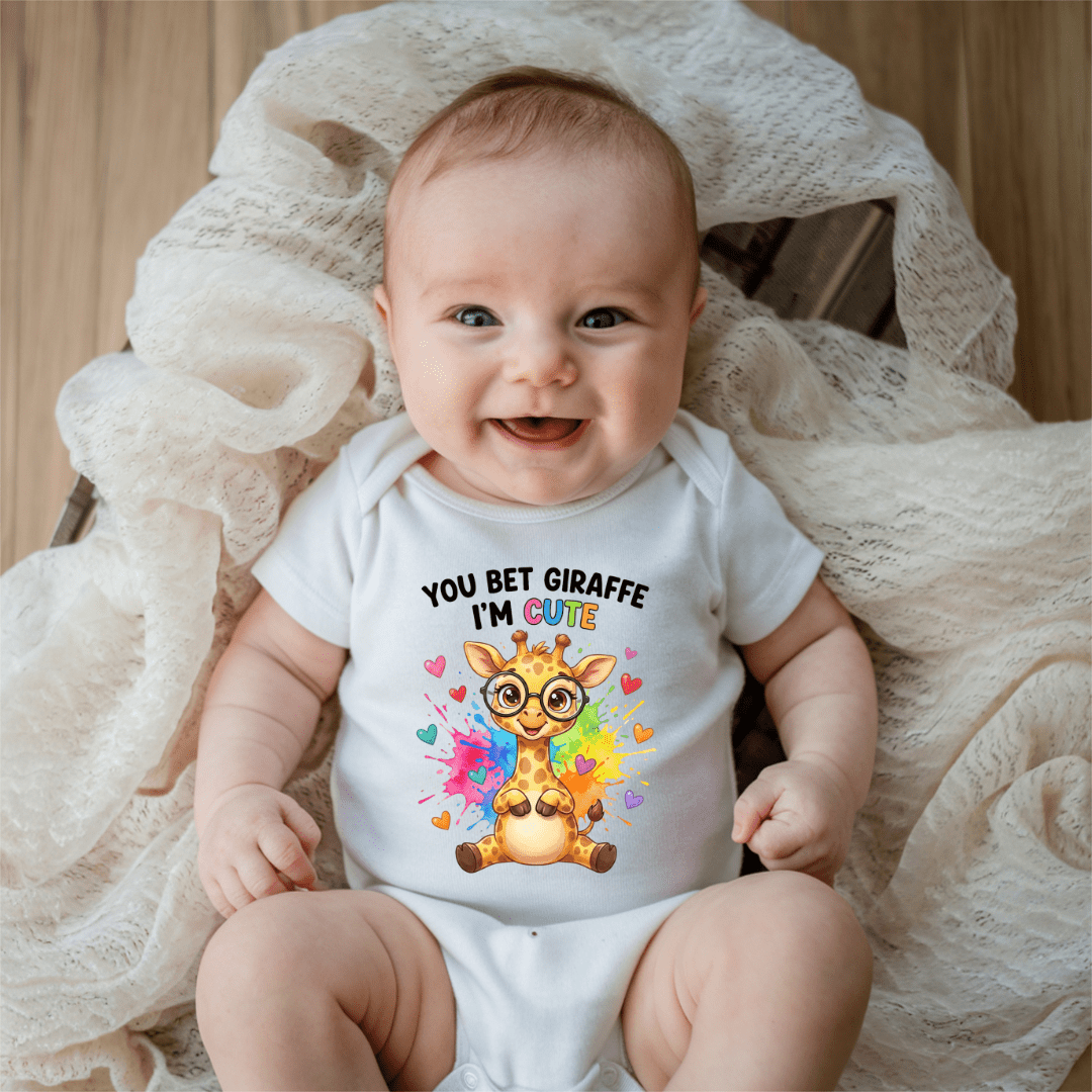 Smiling baby wearing white You Bet Giraffe I’m Cute baby onesie with colourful giraffe and heart design