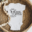Soft white infant onesie with cartoon giraffe graphic perfect for safari nursery themes