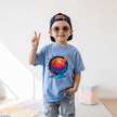 Young boy wearing a Carolina blue kids basketball T shirt with colourful basketball splash artwork on the front.